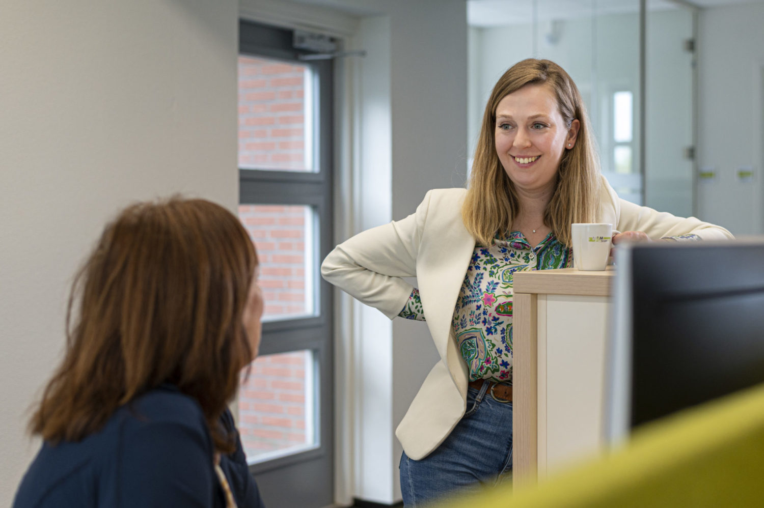 Twee collega's van de NOM met elkaar in gesprek