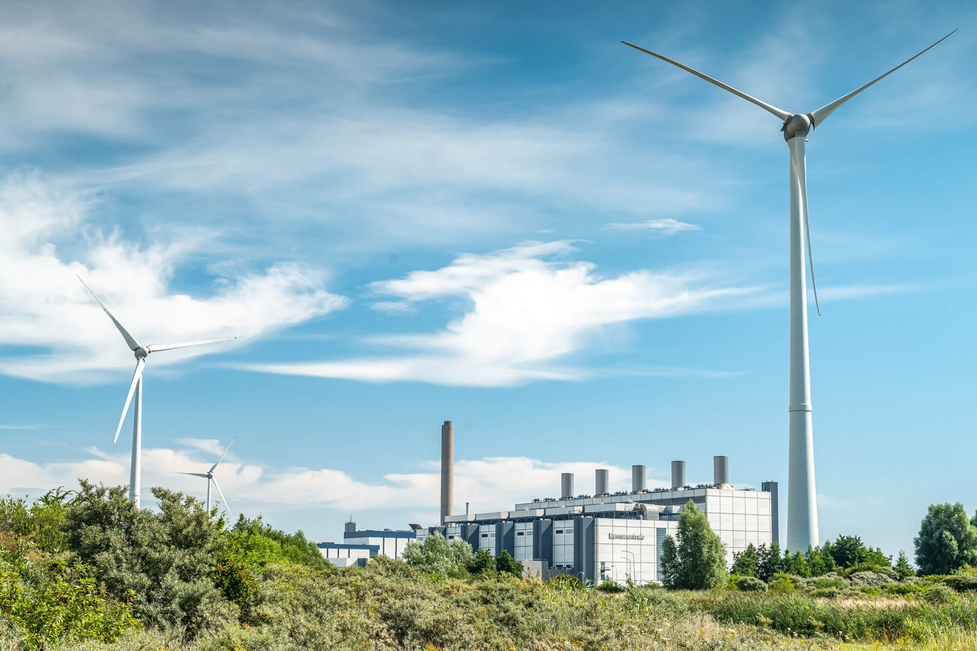 Windmolens met een fabriek op de achtergrond