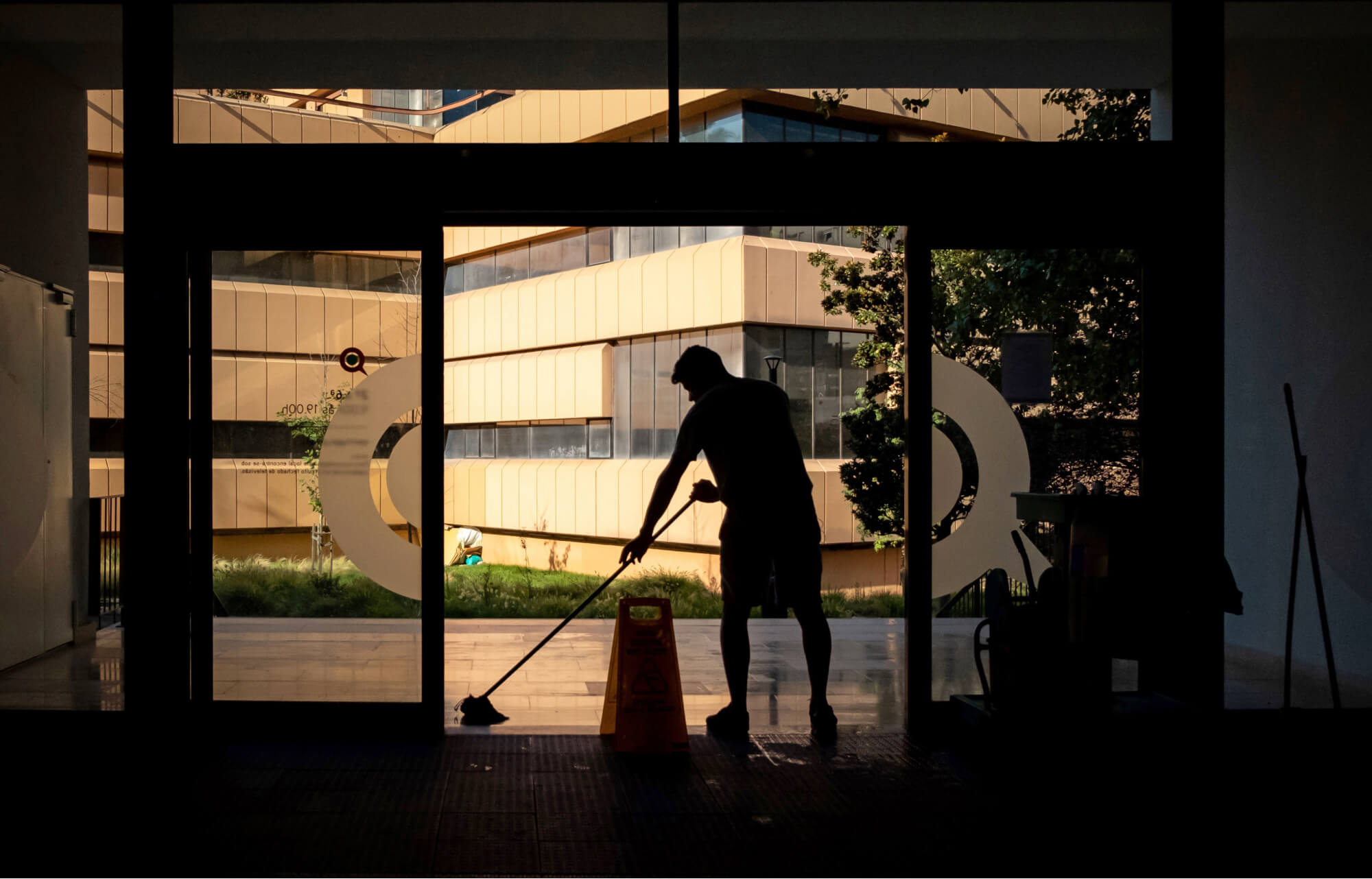 Een schoonmaker die de vloeren dweilt