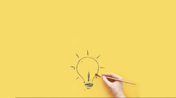 Stock Photo A Burning Light Bulb As A Symbol Of Creativity And An Emerging Idea A Person Draws A Light Bulb 1702939384