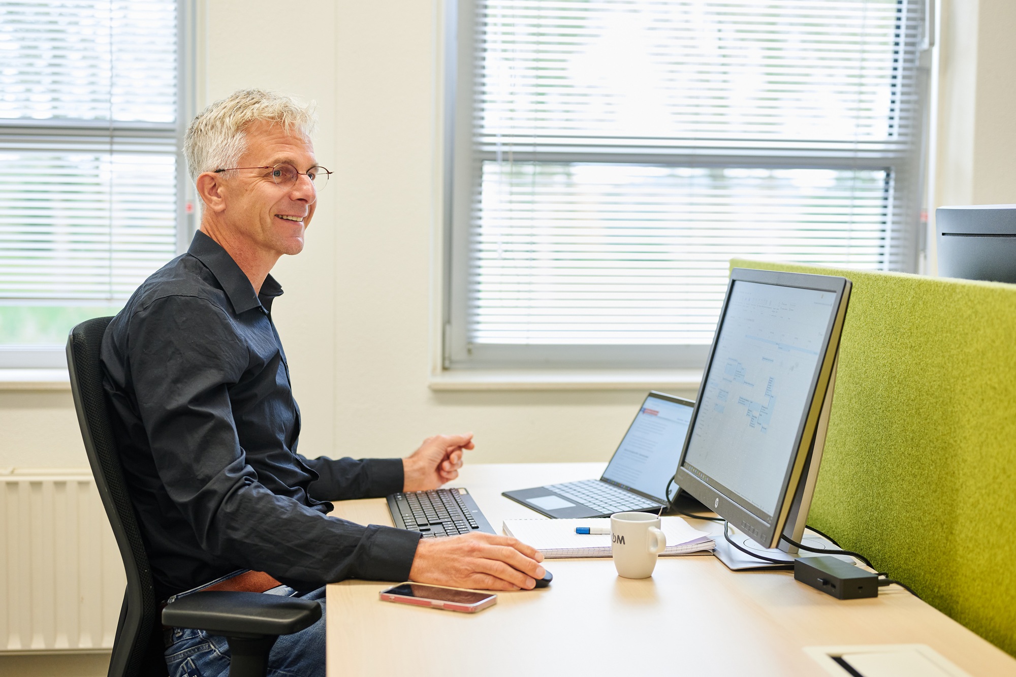 Een NOM collega op het kantoor van de NOM