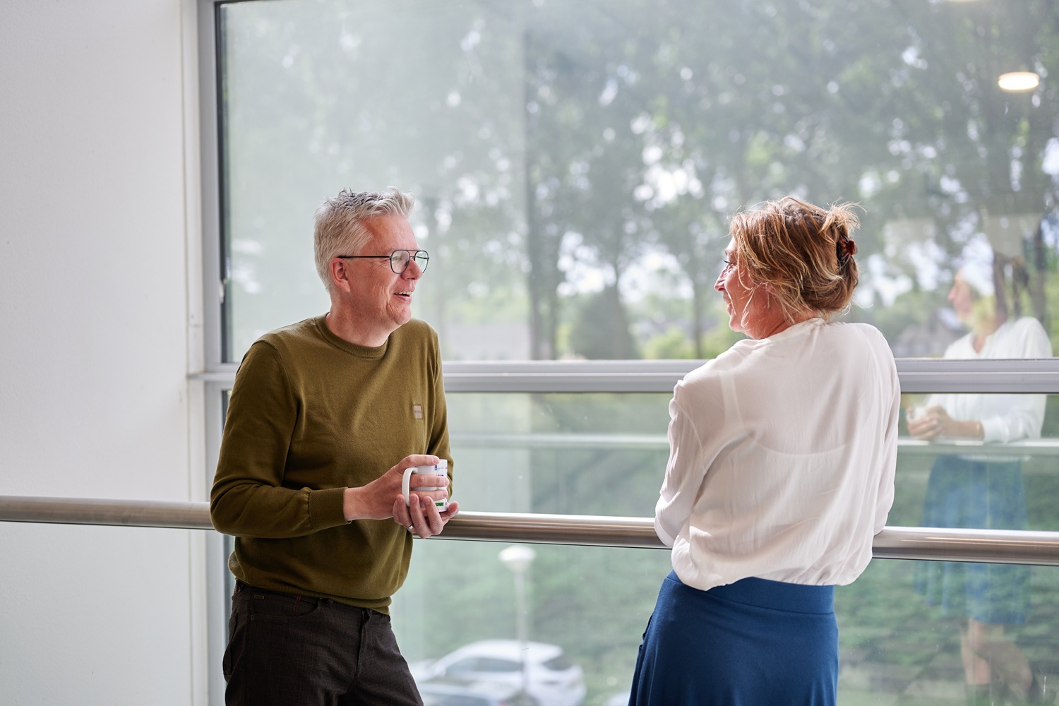 Twee NOM collega's met elkaar in gesprek